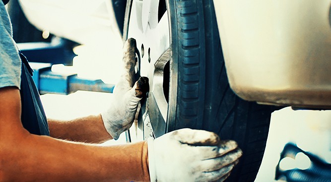 Mechanic-Inspecting-Car-Tire
