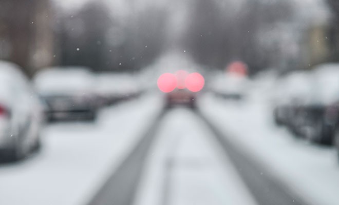 Car-With-Brake-Lights-On-Snowy-Road