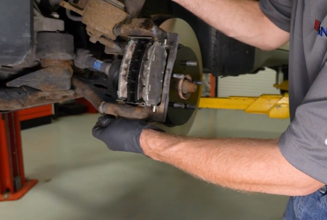 Technician installing brake caliper assembly