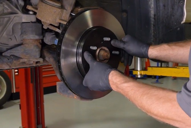 Technician installing brake rotor